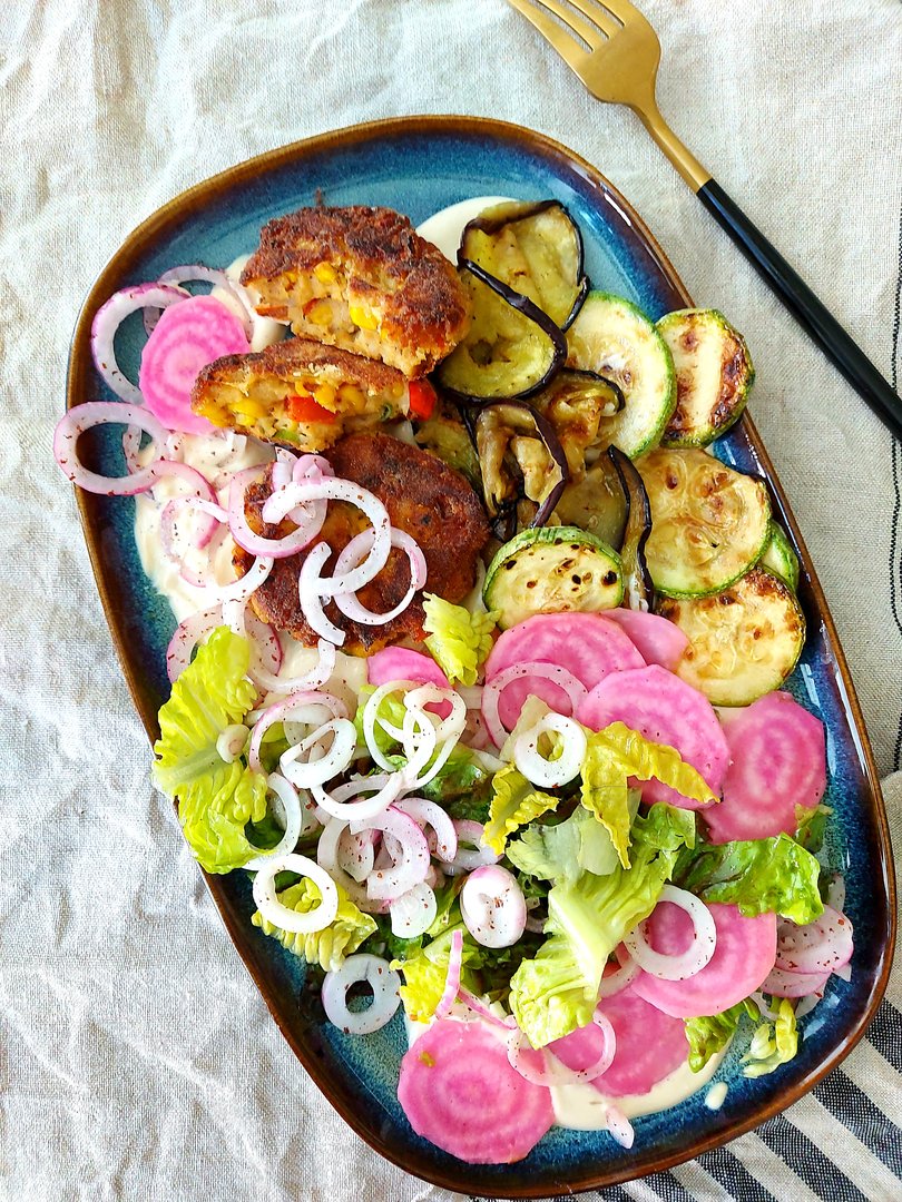 Couscous Laibchen mit gegrillter Melanzani und Zucchini an Joghurt-Tahina Soße, dazu ein Carpaccio von der Ringelbeete und eingelegte Tropea-Zwiebeln