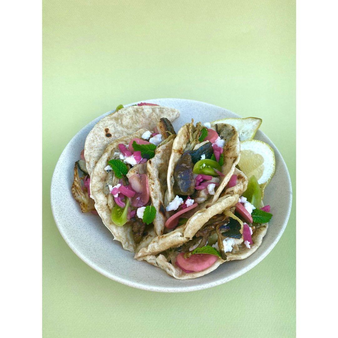 Tacos mit gegrillter Bachorelle, Fenchel, Melanzani mit Babaganoush, Hirtenkäse, eingelegten Radieschen und roten Zwiebeln, Minze und frischer grüner 
